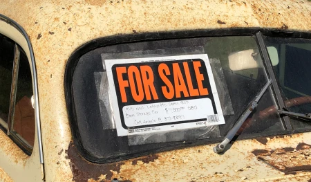 For sale sign in an old car windscreen